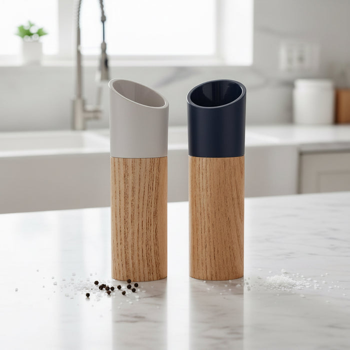 Black and white wooden salt and pepper grinder set displayed on a kitchen counter
