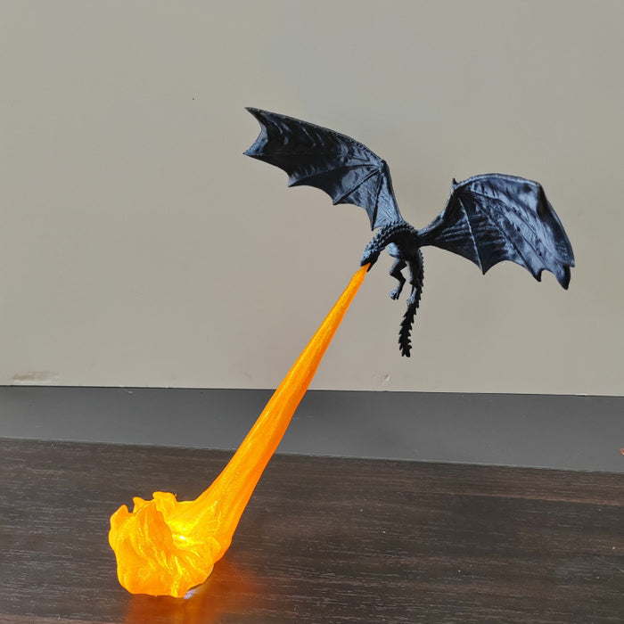 Black dragon night light projecting an orange flame effect onto a tabletop
