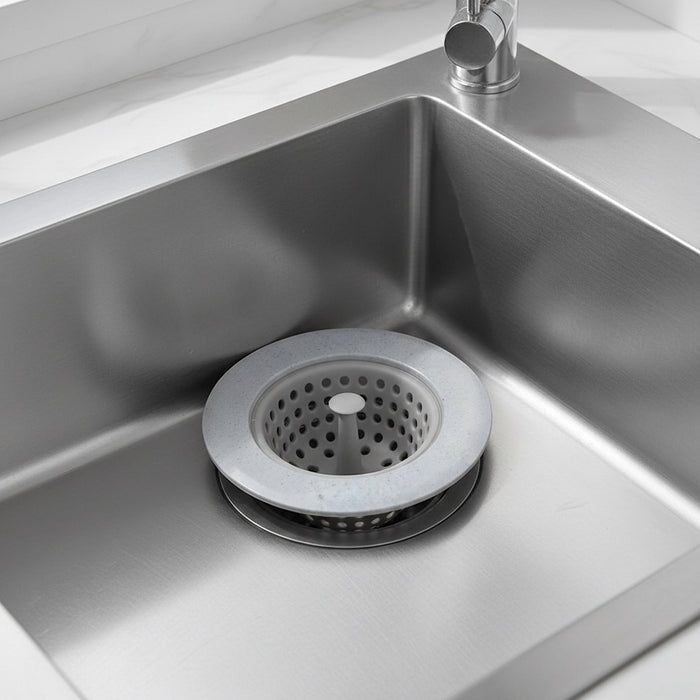 Blue silicone sink drain strainer fitted over a stainless steel kitchen sink drain.