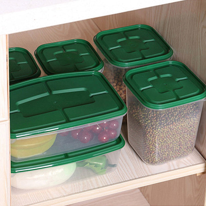 Green-lid stackable food storage containers organizing grains and fruit inside a kitchen cabinet.