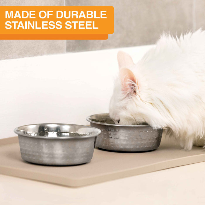 Picture of a cat eating from the Hammered Stainless Steel Bowl in a kitchen. Text on screen reads: Made of durable stainless steel.