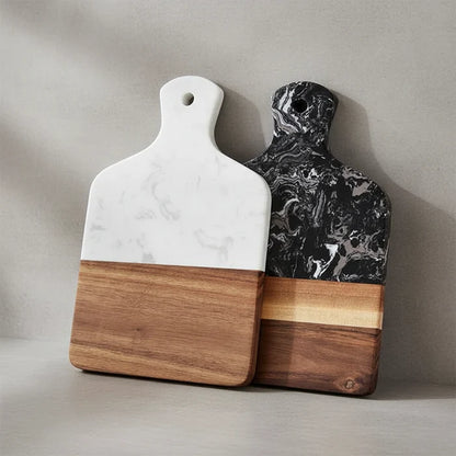 White and black marble and acacia wood serving boards standing side by side