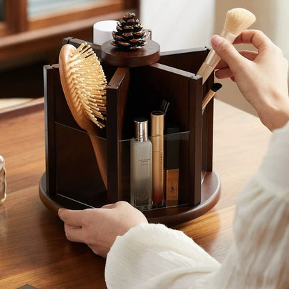 Rotating wooden makeup organizer holding cosmetics, makeup brushes, perfume, and a hairbrush on a vanity