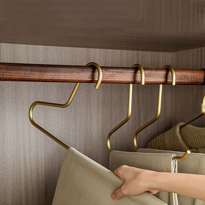 Person sliding folded pants onto a gold open-ended space-saving closet hanger