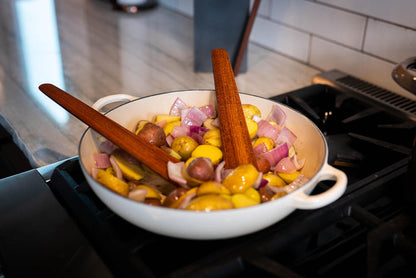 two thin wooden spatulas for cooking in pan on stove - Earlywood